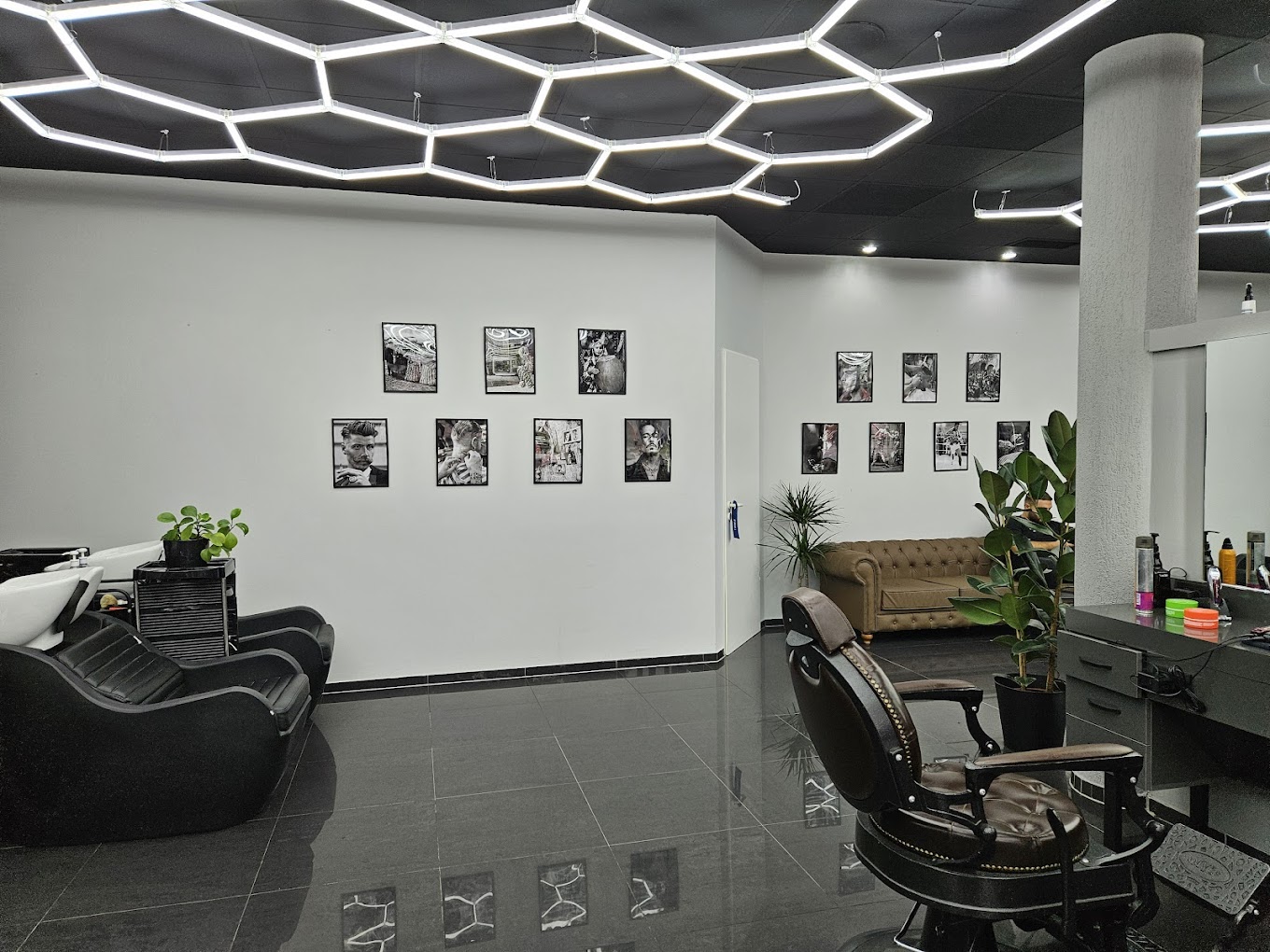 Innenraum von Golden Cut mit modernen Barber-Stühlen, Lounge und markanter Deckenbeleuchtung